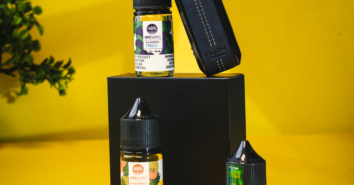 E-liquid bottles and a vape device on a yellow background